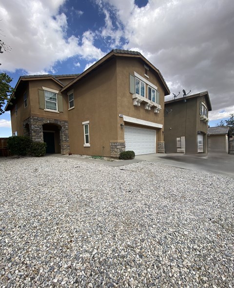 A house with a gravel driveway in front.