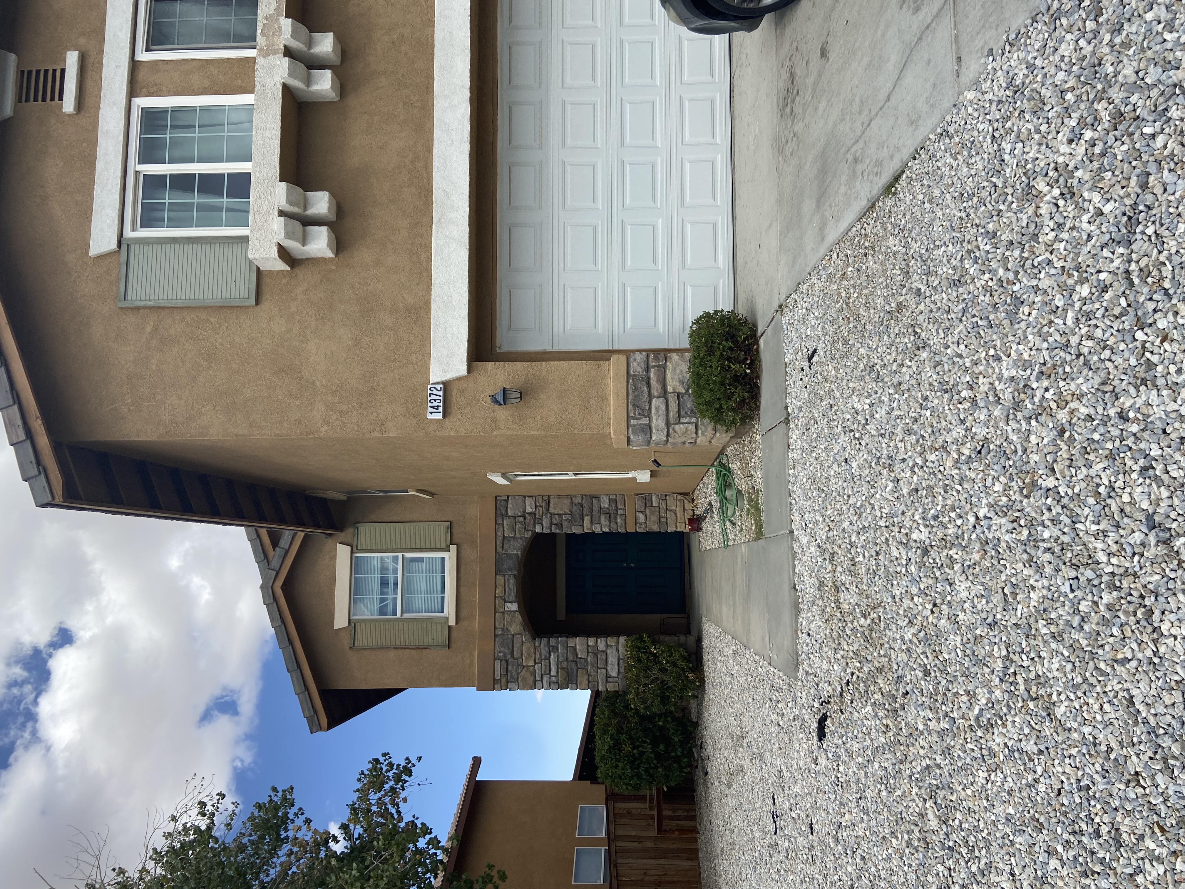 A house with a brown exterior and a white garage door.