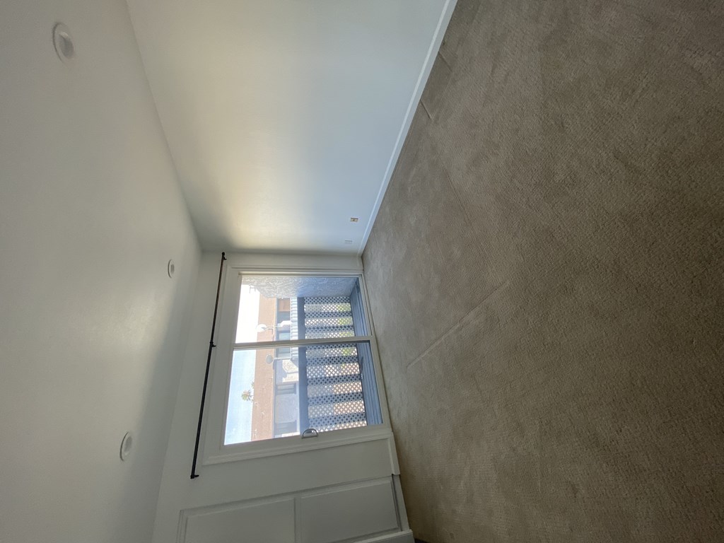 A stairwell with a metal railing and a window.