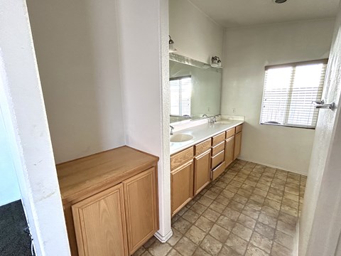 A bathroom with a sink, mirror, and wooden cabinet.