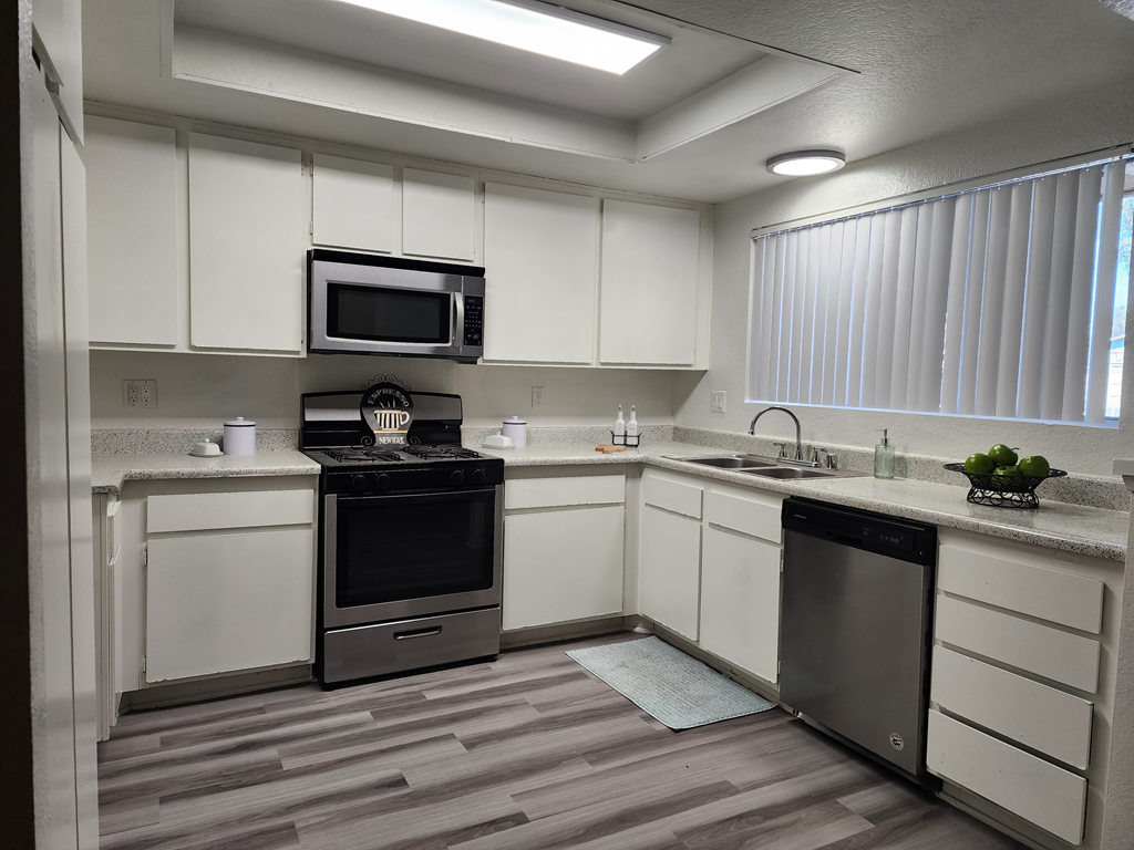 a kitchen with white cabinets and stainless steel appliances