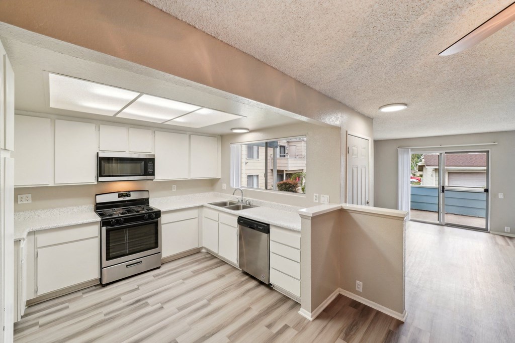 a kitchen with white cabinets and stainless steel appliances
