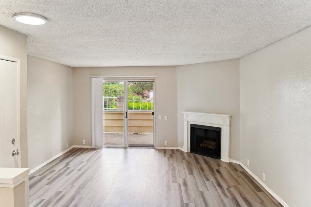 an empty living room with a fireplace and a window
