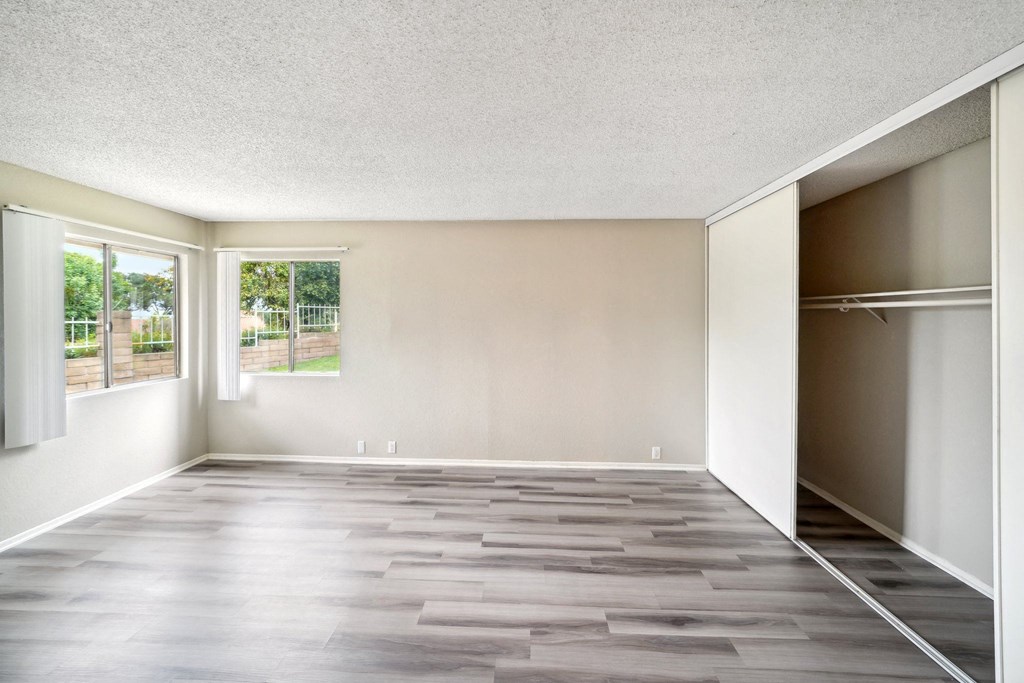 an empty room with a closet and a window