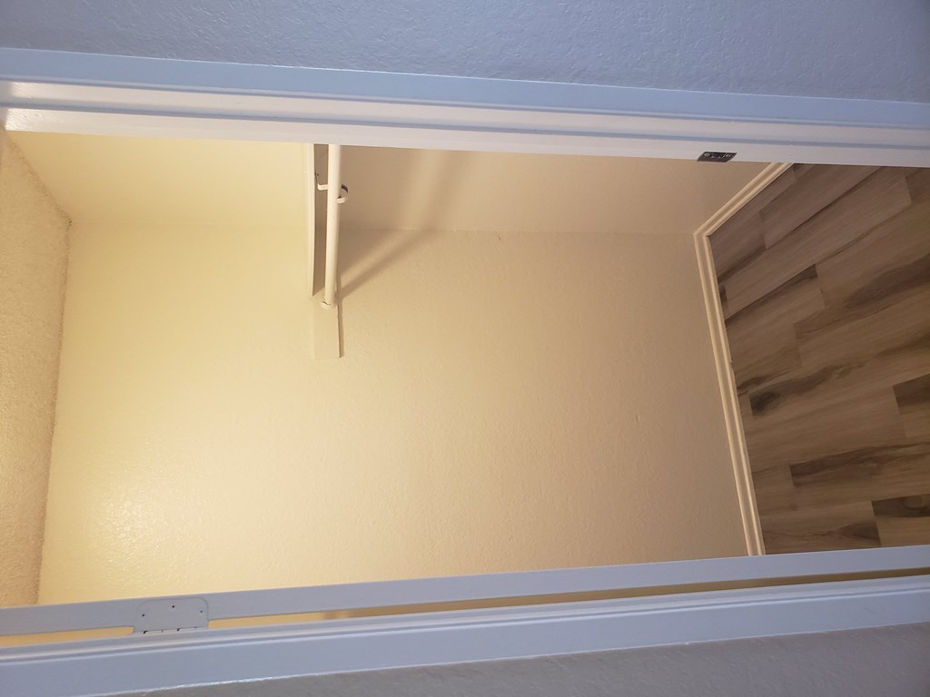 an open door with a wood floor in the background and a yellow wall with a white trim