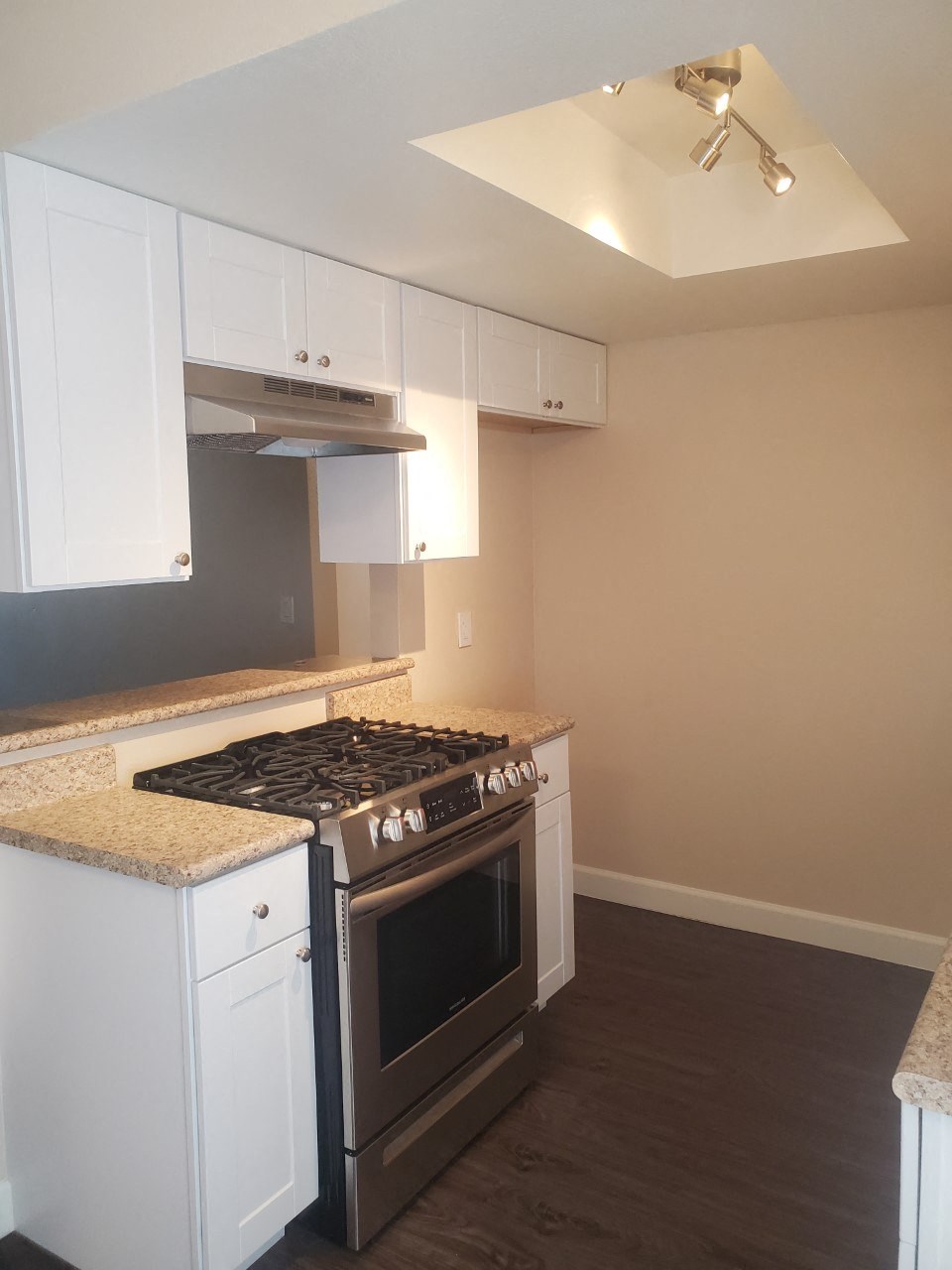 a kitchen with white cabinets and a stove