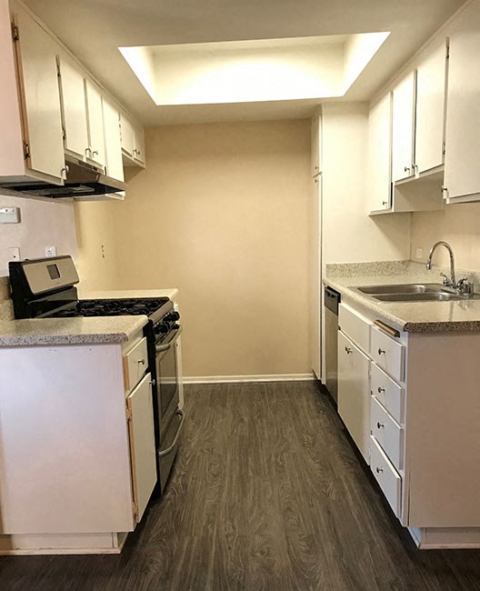 an empty kitchen with a stove and a sink