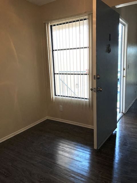 an empty room with a large window and a door