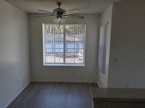 a living room with a large window and a ceiling fan