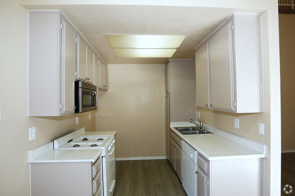 a kitchen with white cabinets and a stove and a sink