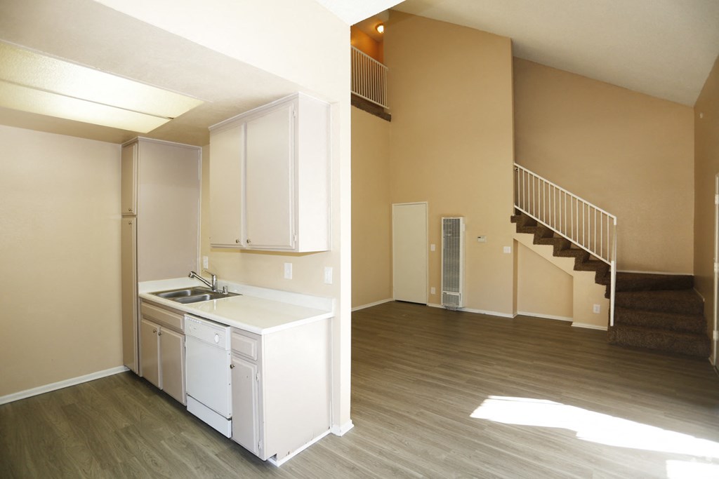 an empty kitchen and living room with a staircase in a house