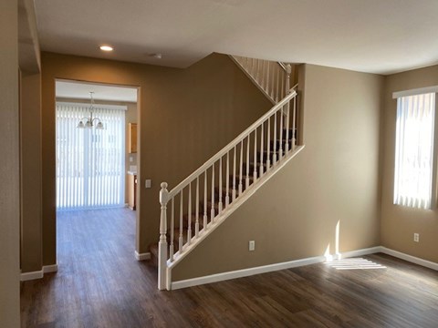 A spacious room with a staircase leading to the second floor.