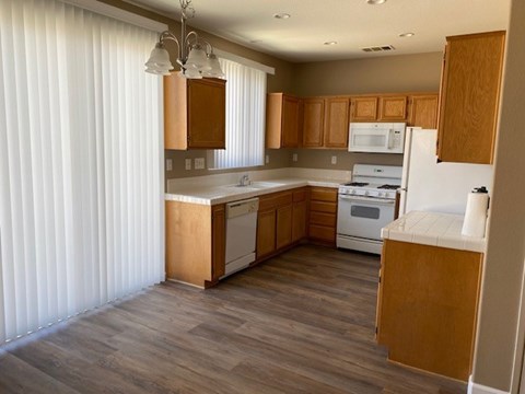 A kitchen with wooden cabinets and a white oven.