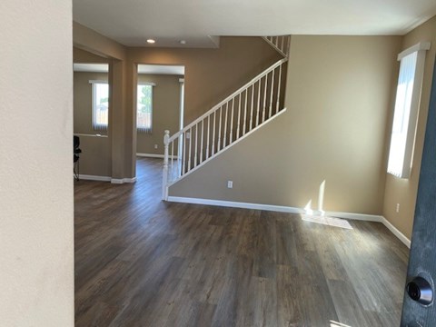 A room with a wooden floor and a staircase.