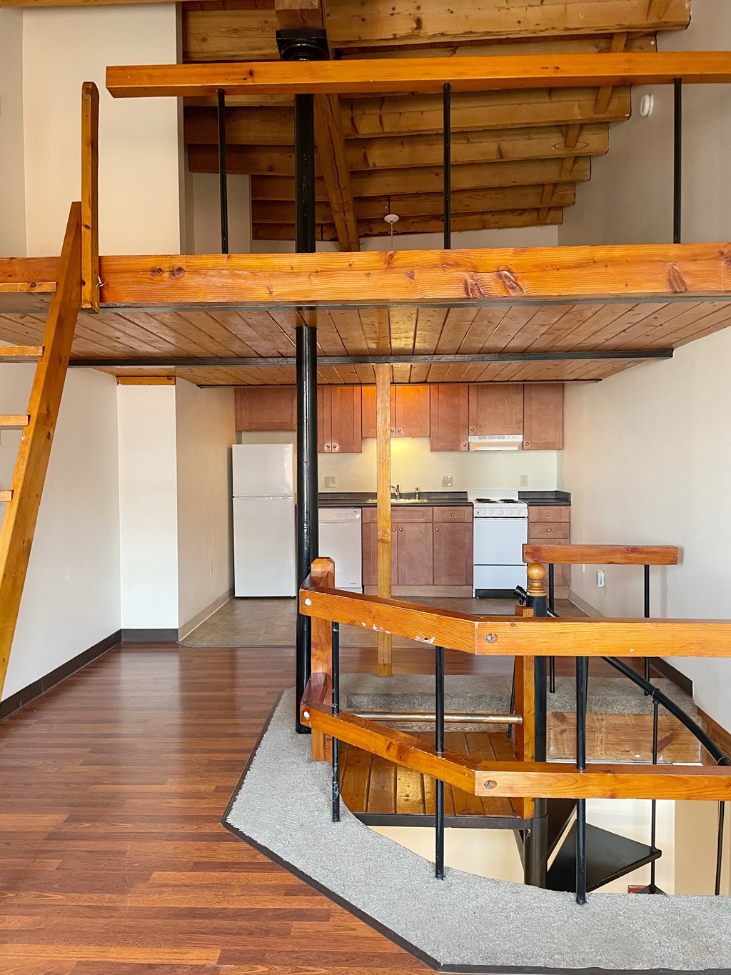 a view of a living room and a kitchen with a loft