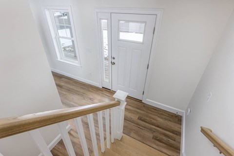 A white door is in a room with a wooden floor.