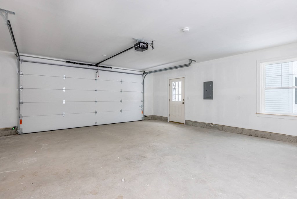 A spacious garage with a white door and a window.