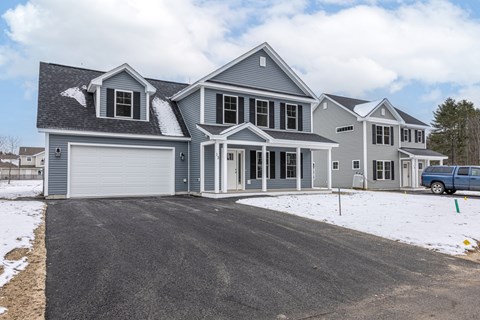 A large house with a grey roof and a white garage door.