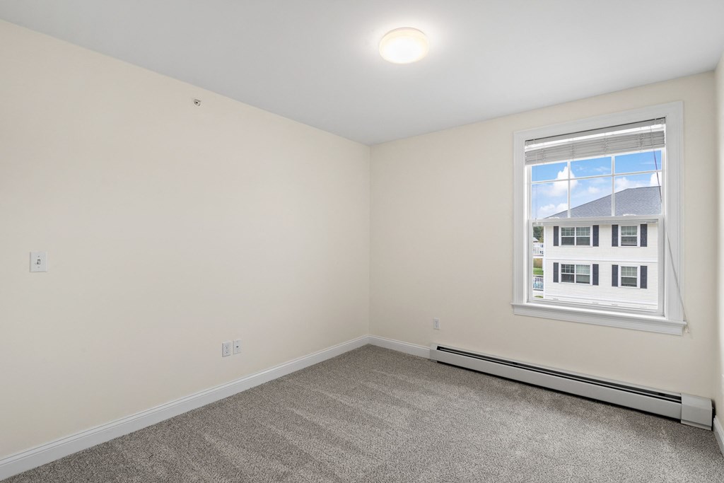 an empty room with carpet and a window
