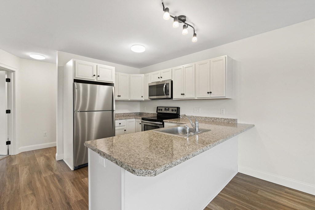 a kitchen with a granite counter top and a stainless steel refrigerator