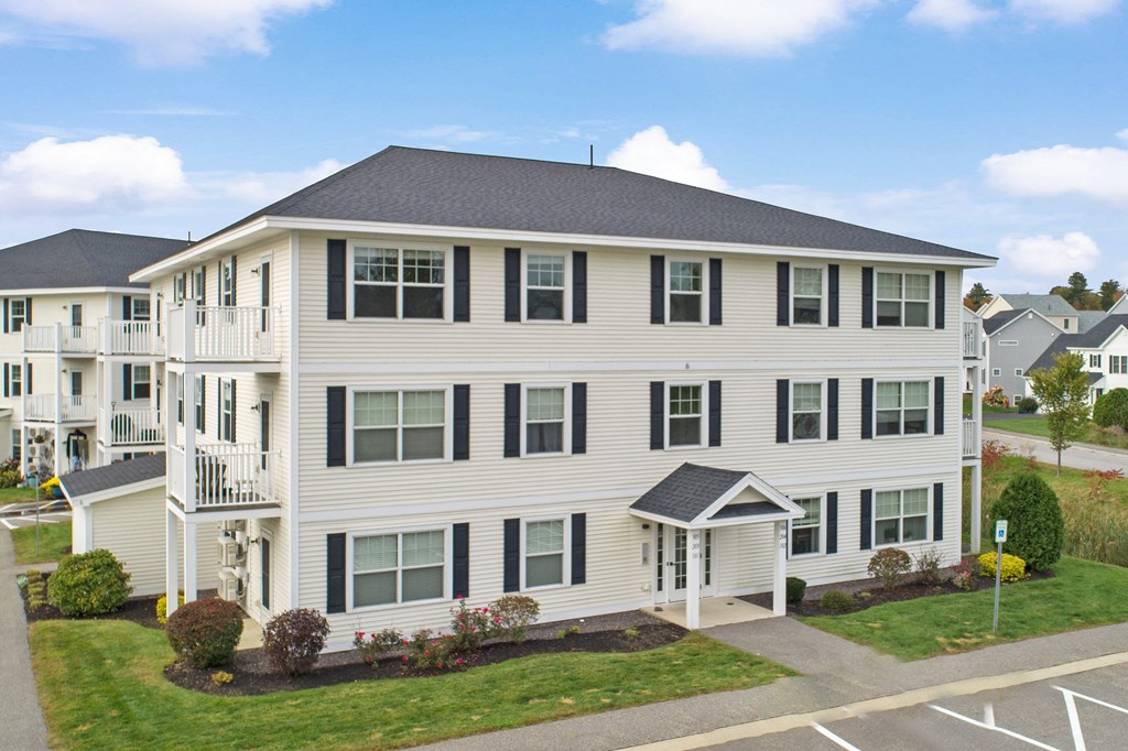 a large white apartment building with a street in front of it