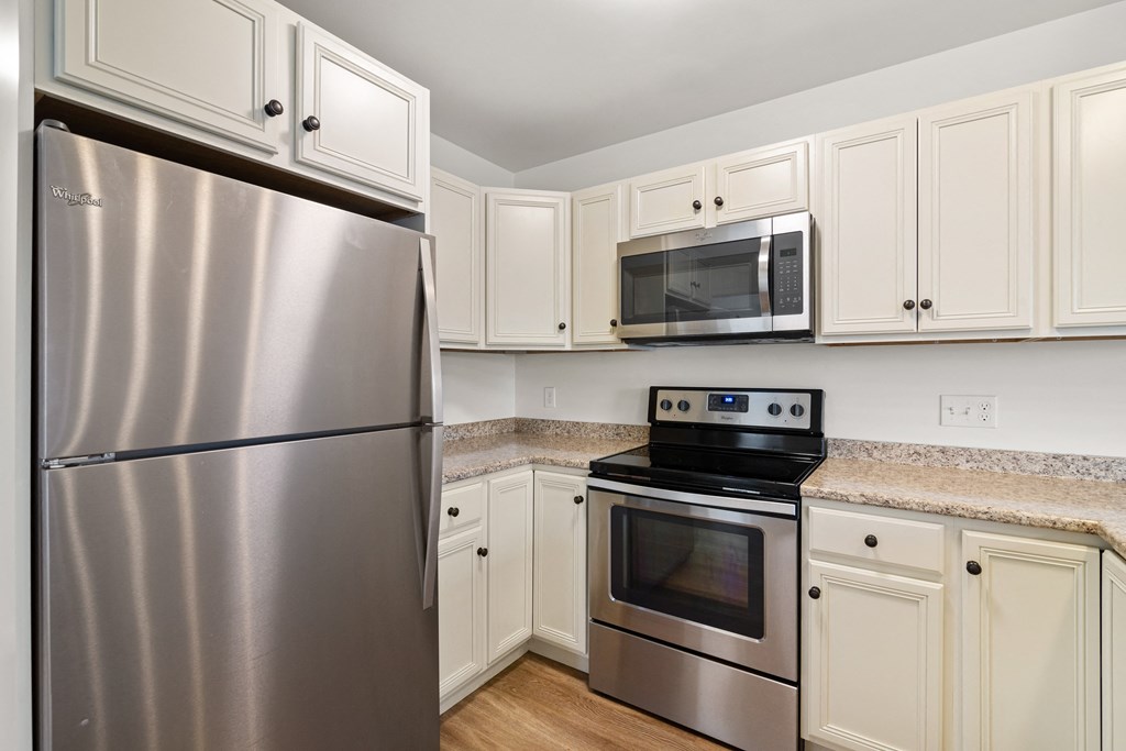 a kitchen with stainless steel appliances and white cabinets