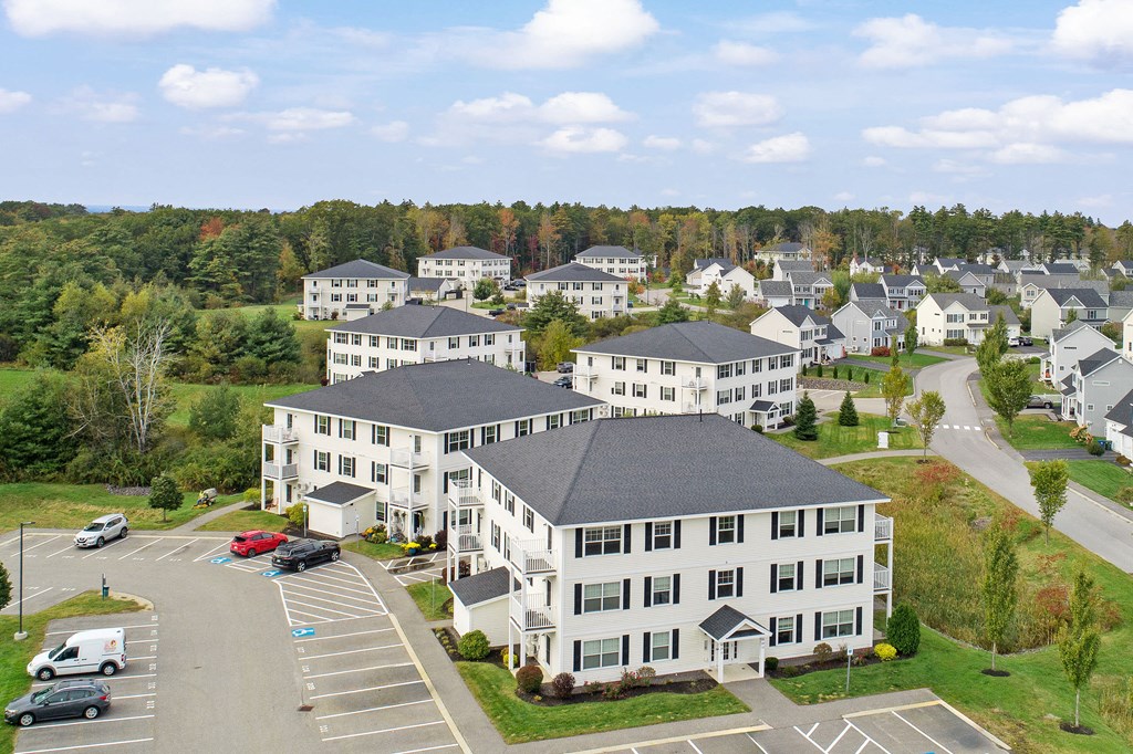 an aerial view of an apartment complex with cars parked in a parking lot