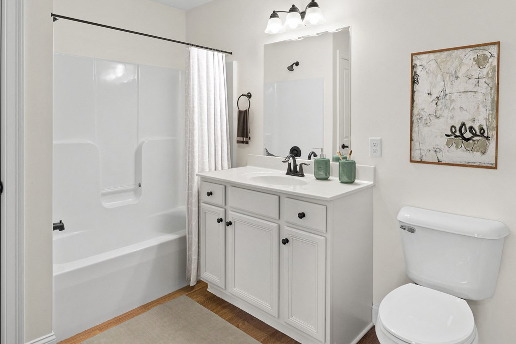 a white bathroom with a shower sink and toilet