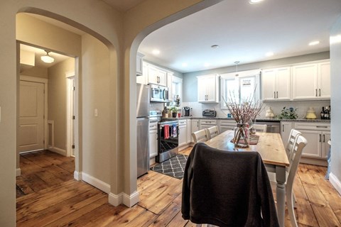 A kitchen with a table and chairs in the middle of it.
