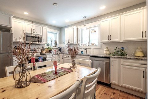 A kitchen with a table and chairs in the foreground.