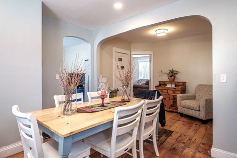 A dining room with a wooden table and chairs.