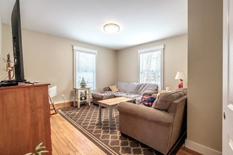 A living room with a brown couch and a wooden cabinet.