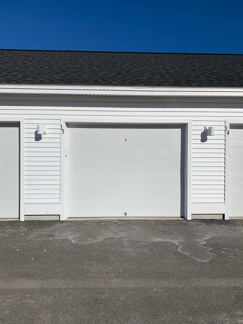 Two white garage doors on a building.