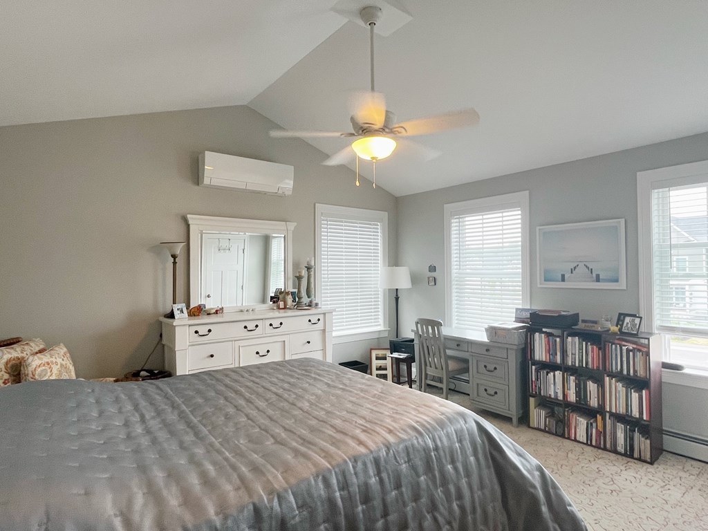 A bedroom with a bed, dresser, and a ceiling fan.
