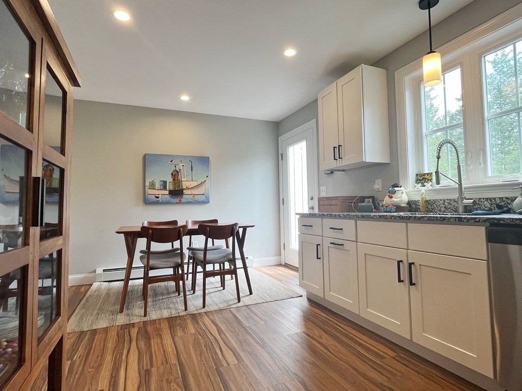 A kitchen with wooden floors and a table with chairs.