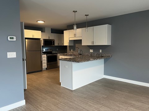A kitchen with a refrigerator, oven, and microwave.