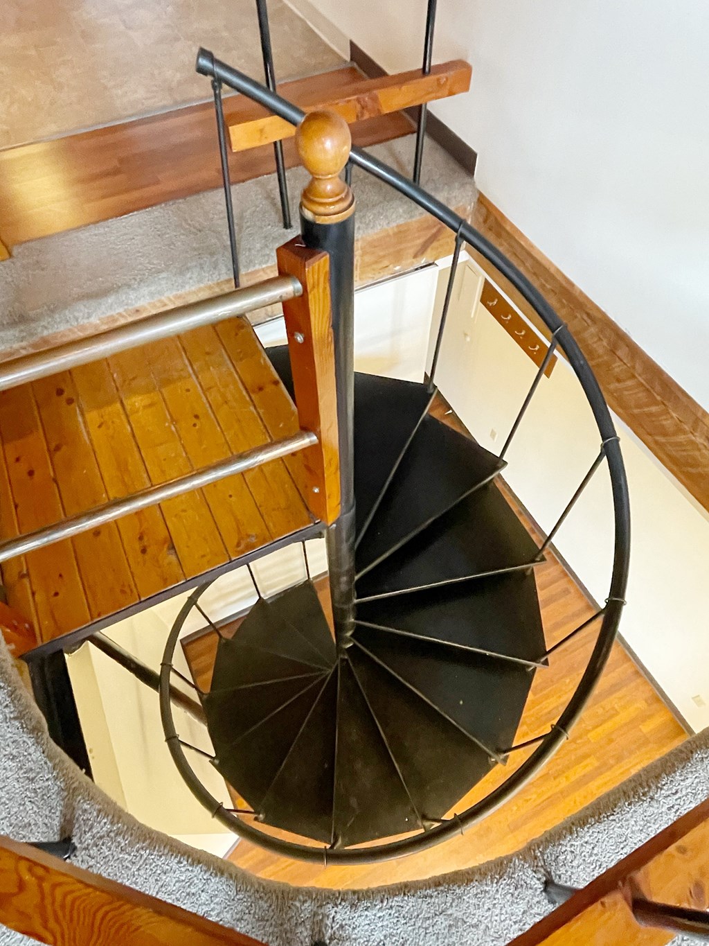 a spiral staircase in a house with a wooden railing and a wooden