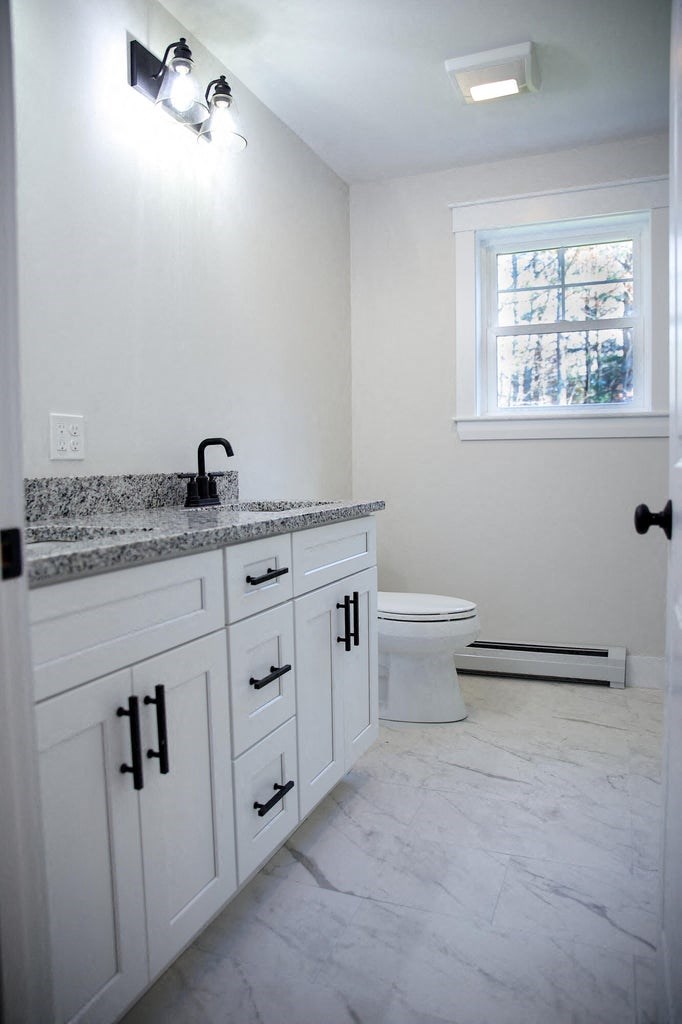 a bathroom with a sink and a toilet and a window