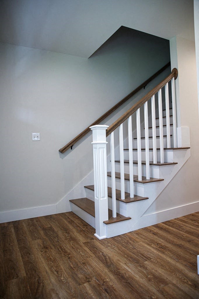 a white staircase with wood floors and white walls