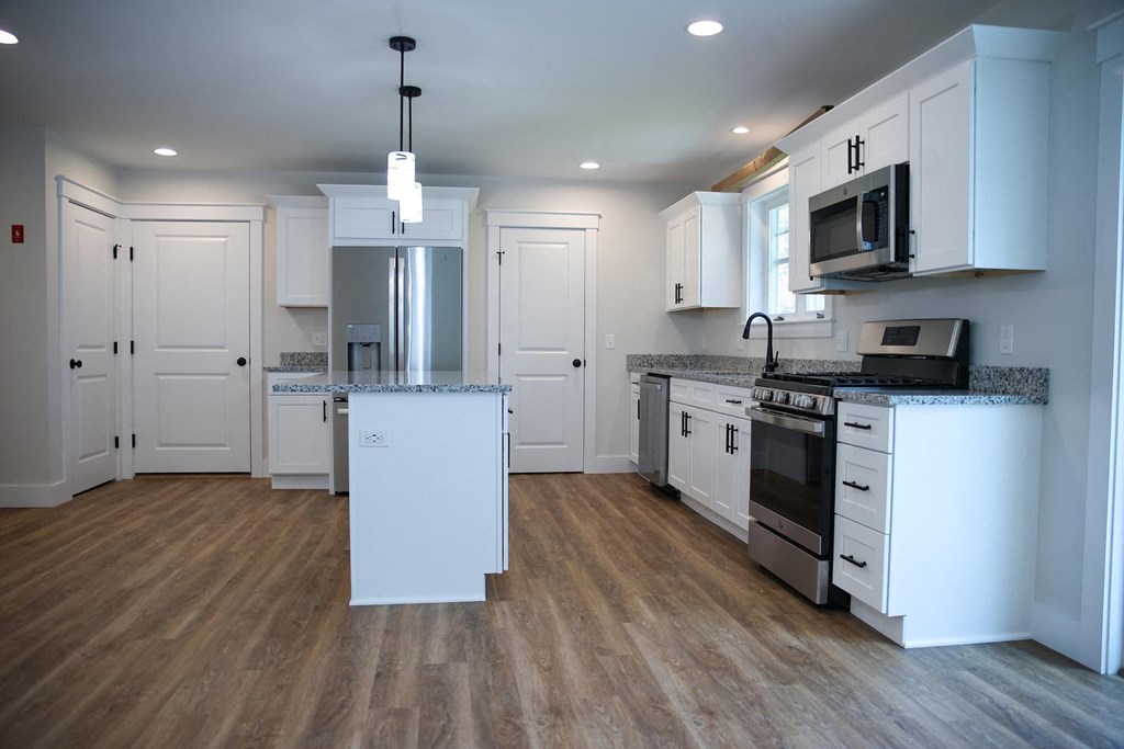 a kitchen with white cabinets and stainless steel appliances