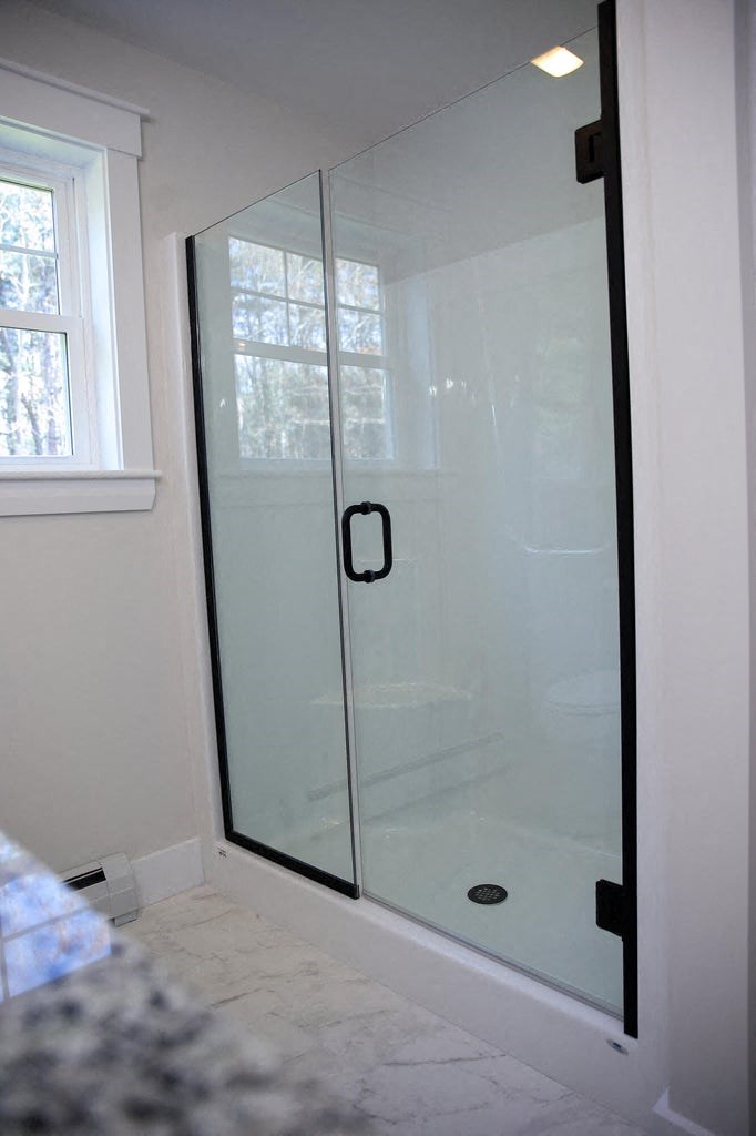 a shower with a glass door in a bathroom