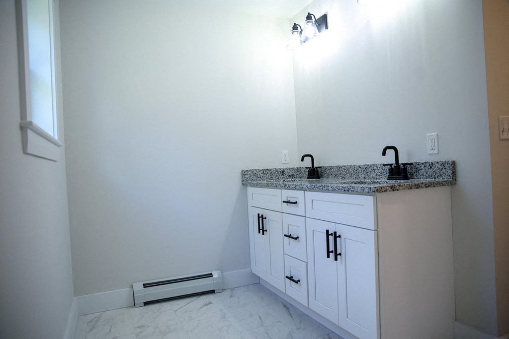 a bathroom with white cabinets and a sink and a mirror