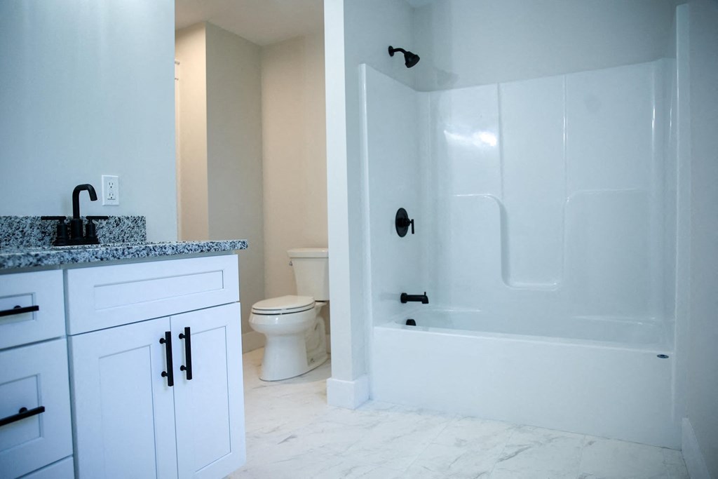 a bathroom with a shower and a sink and a toilet
