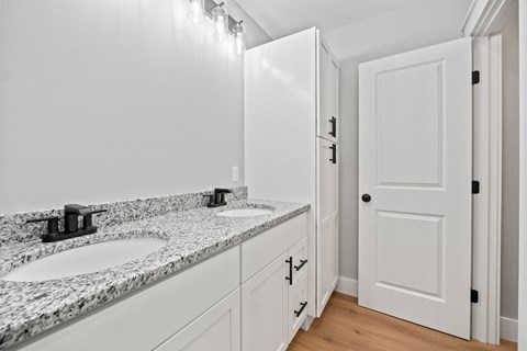 a bathroom with two sinks and a white door