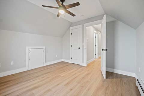 an empty living room with white walls and a ceiling fan