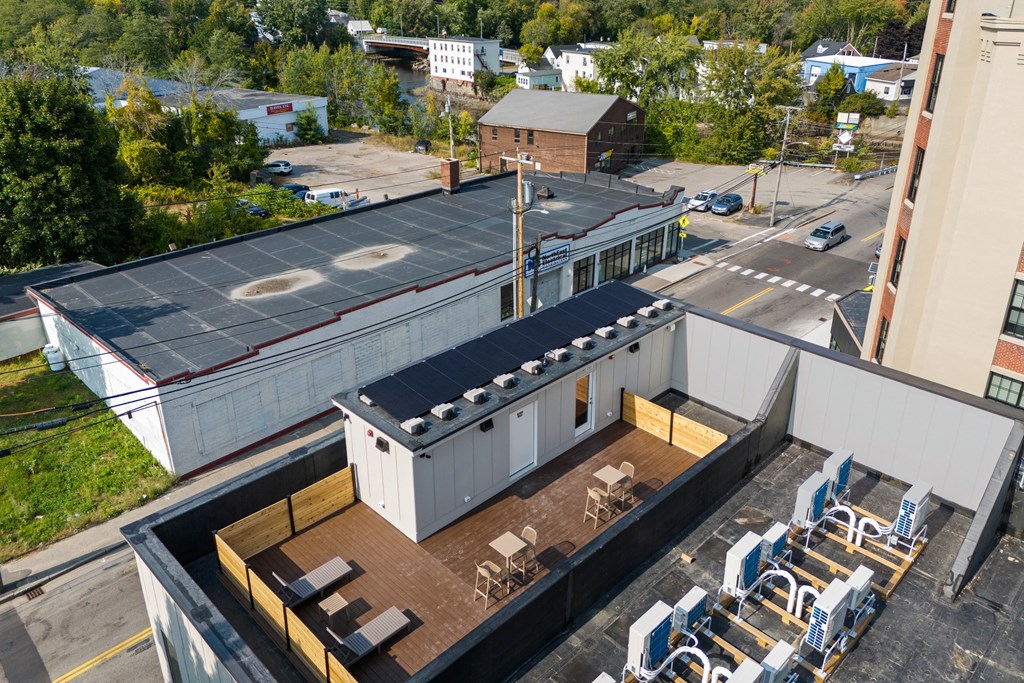an aerial view of a building with a rooftop patio and tables and chairs