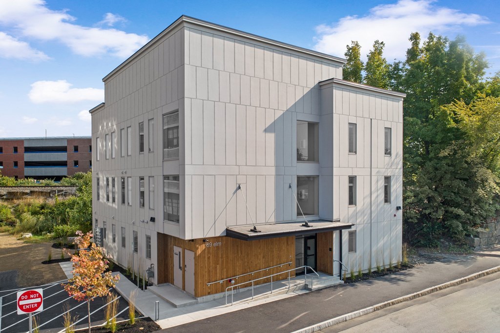 the exterior of a white building with a wood facade