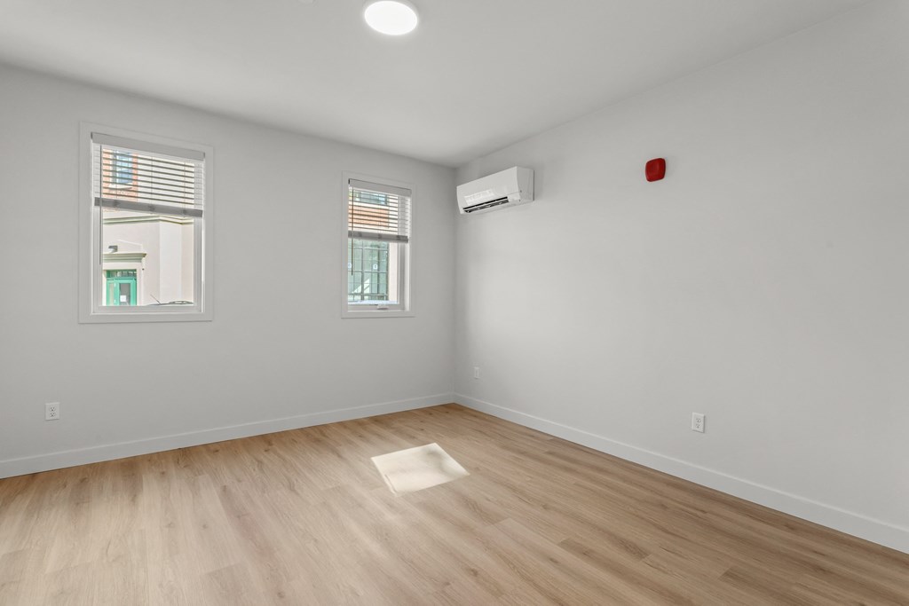 an empty living room with white walls and wood floors