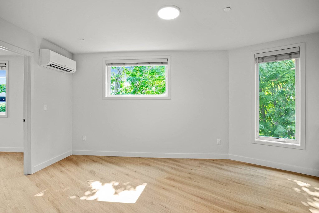 an empty room with white walls and a window