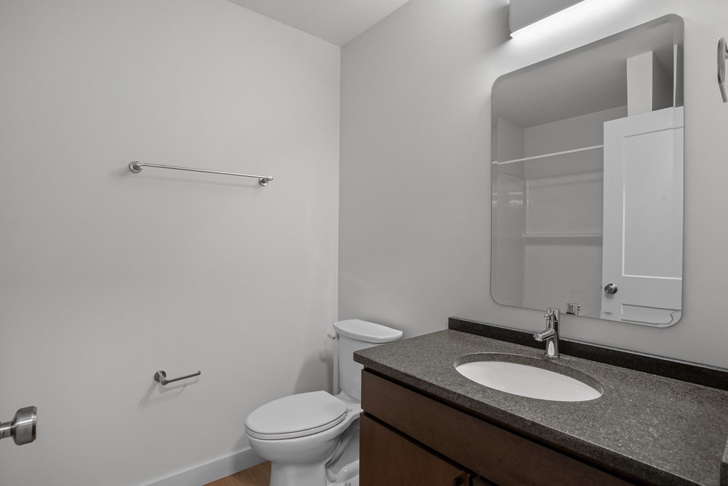 an empty bathroom with a toilet sink and mirror